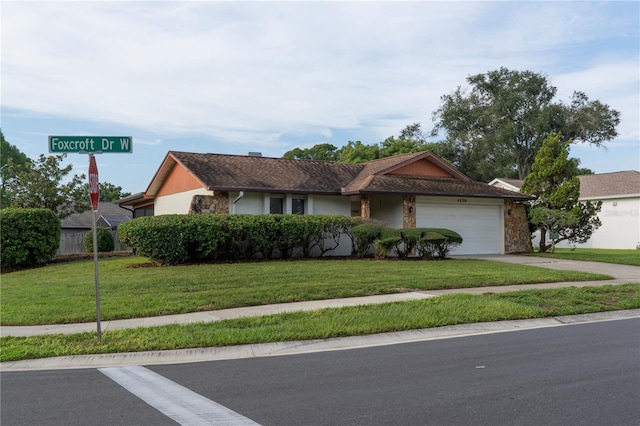 ranch-style home featuring a garage and a front lawn