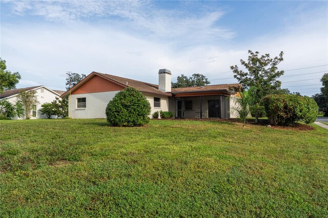 rear view of property with a yard