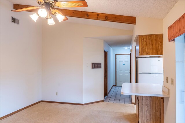 kitchen featuring ceiling fan, light colored carpet, white refrigerator, and a textured ceiling