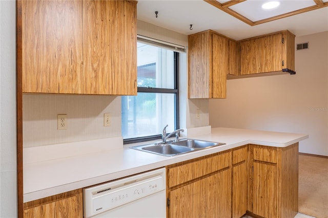 kitchen with white dishwasher, kitchen peninsula, light colored carpet, and sink