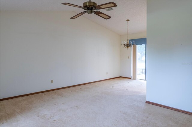 carpeted empty room featuring a textured ceiling, ceiling fan with notable chandelier, and vaulted ceiling