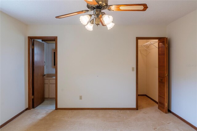 interior space featuring ceiling fan, a textured ceiling, and light carpet