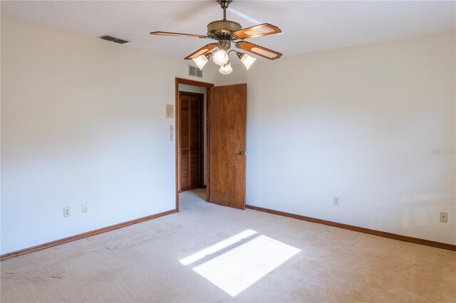 unfurnished room featuring ceiling fan and light colored carpet