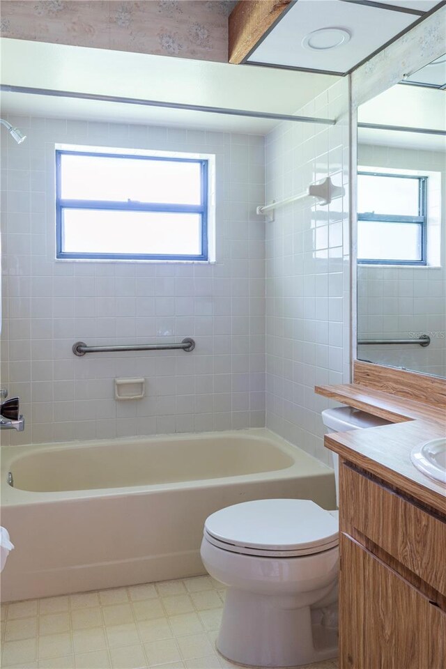 full bathroom featuring tiled shower / bath combo, vanity, and toilet