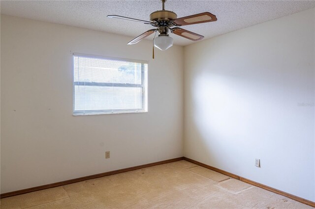 spare room with a textured ceiling, ceiling fan, and light colored carpet