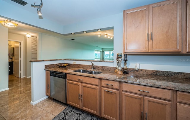 kitchen with sink, stainless steel dishwasher, dark stone countertops, light tile patterned flooring, and kitchen peninsula