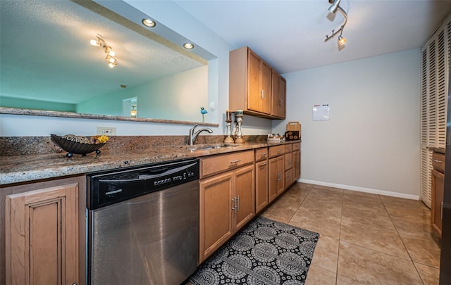 kitchen featuring a textured ceiling, sink, light tile patterned floors, stone counters, and dishwasher