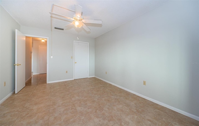 unfurnished bedroom with ceiling fan and a textured ceiling