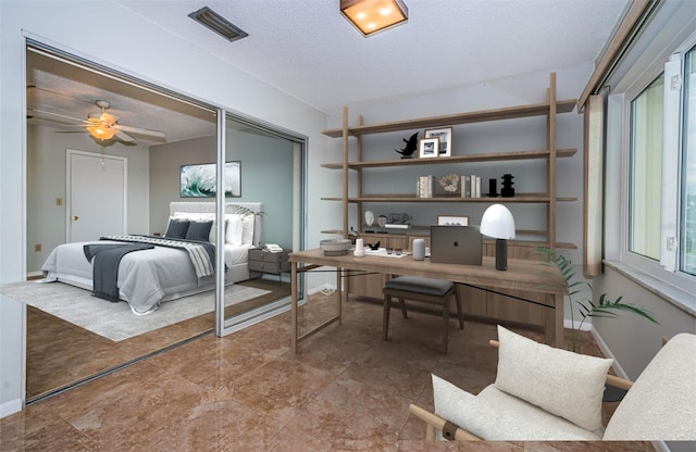 bedroom featuring ceiling fan, a textured ceiling, and a closet