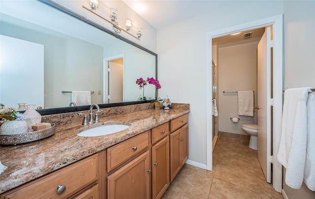 bathroom featuring tile patterned flooring, vanity, and toilet