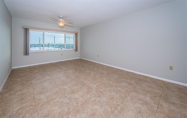 spare room with light tile patterned floors, a textured ceiling, and ceiling fan