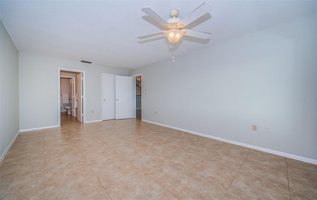 tiled empty room with a textured ceiling and ceiling fan