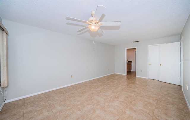 unfurnished bedroom with ceiling fan and a textured ceiling