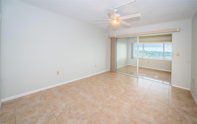 unfurnished bedroom featuring ceiling fan, light tile patterned floors, a textured ceiling, and a closet