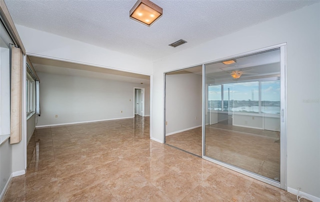 spare room with a textured ceiling and a water view