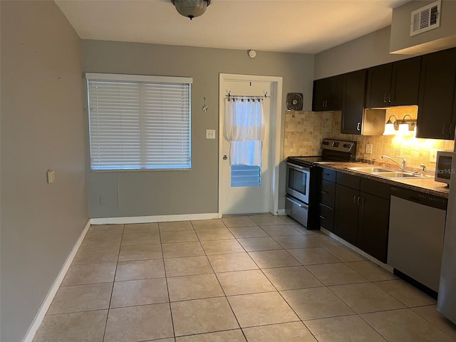 kitchen with light tile patterned flooring, sink, stainless steel appliances, and tasteful backsplash