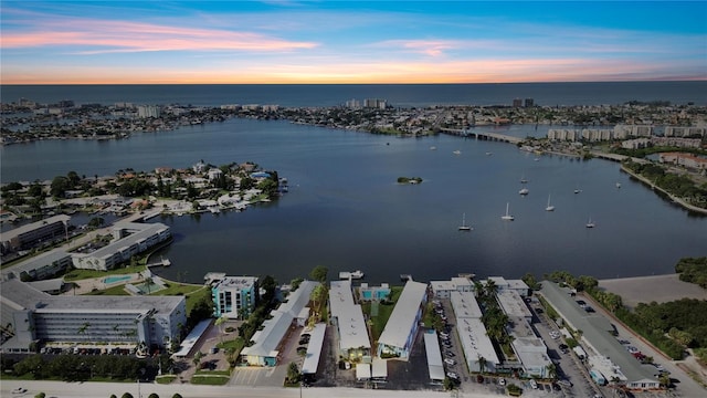 aerial view at dusk featuring a water view