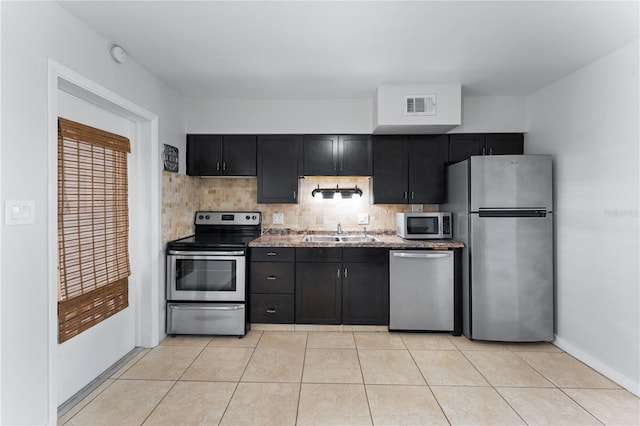 kitchen featuring backsplash, appliances with stainless steel finishes, light tile patterned flooring, and sink