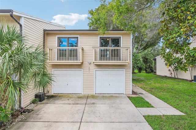 view of front of home with driveway, a balcony, an attached garage, and a front lawn