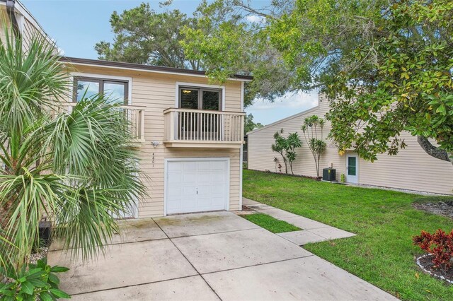 view of front of house with driveway, central AC unit, a balcony, an attached garage, and a front lawn