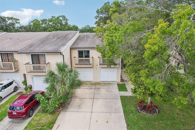 multi unit property featuring a garage and concrete driveway