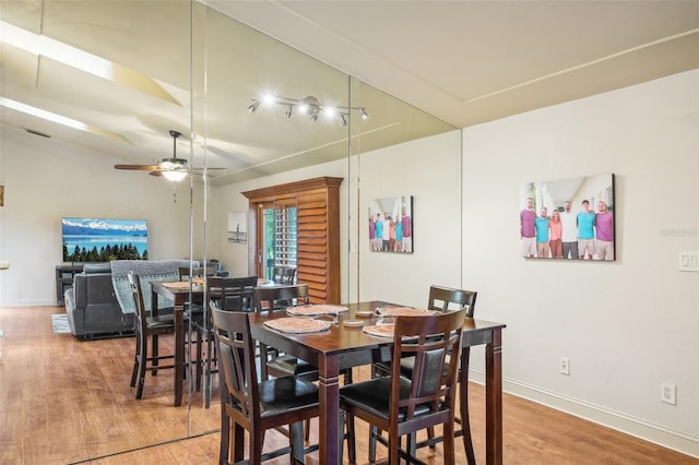 dining area featuring baseboards, ceiling fan, and light wood finished floors