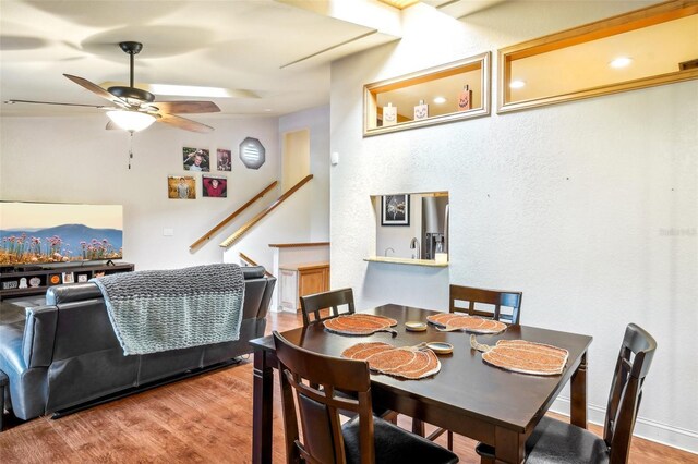 dining space with a ceiling fan and wood finished floors