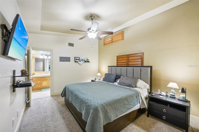 bedroom featuring baseboards, visible vents, light colored carpet, ensuite bath, and ceiling fan