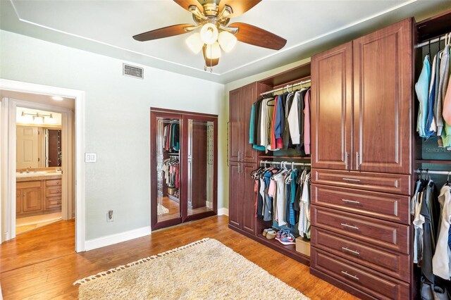 interior space featuring baseboards, visible vents, a sink, and light wood finished floors