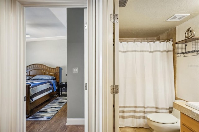 bathroom with curtained shower, visible vents, toilet, vanity, and wood finished floors