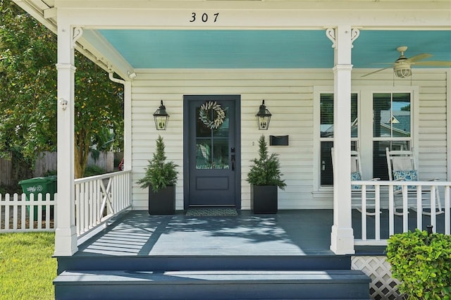 entrance to property with ceiling fan and a porch