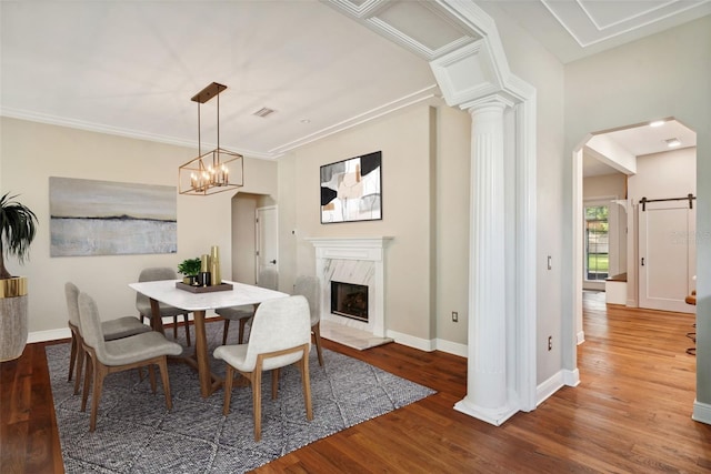 dining space with a chandelier, a fireplace, ornamental molding, and hardwood / wood-style flooring