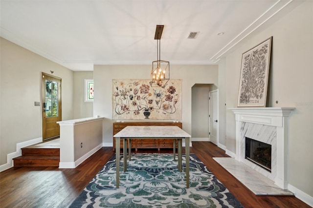 dining area featuring a premium fireplace, dark hardwood / wood-style flooring, and a chandelier