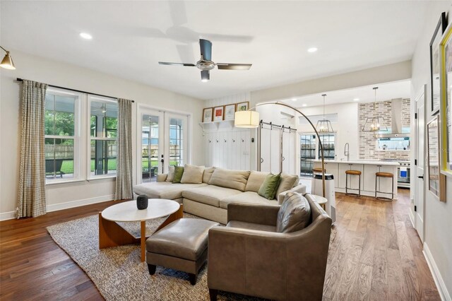 living room with ceiling fan, hardwood / wood-style floors, and sink