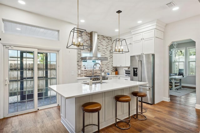 kitchen with high end fridge, wood-type flooring, a healthy amount of sunlight, and hanging light fixtures