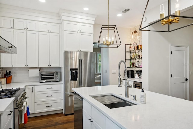 kitchen with dark hardwood / wood-style flooring, premium appliances, sink, pendant lighting, and white cabinets