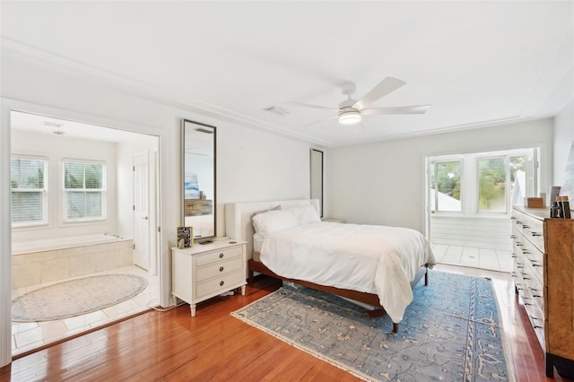 bedroom with multiple windows, ceiling fan, and hardwood / wood-style flooring