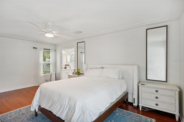 bedroom with dark hardwood / wood-style flooring, ensuite bath, and ceiling fan