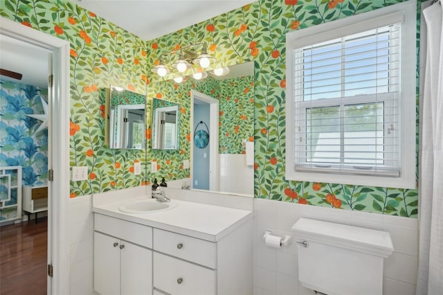 bathroom featuring hardwood / wood-style floors, vanity, tile walls, and toilet