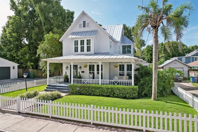 view of front facade with an outbuilding, a front lawn, a porch, and a garage