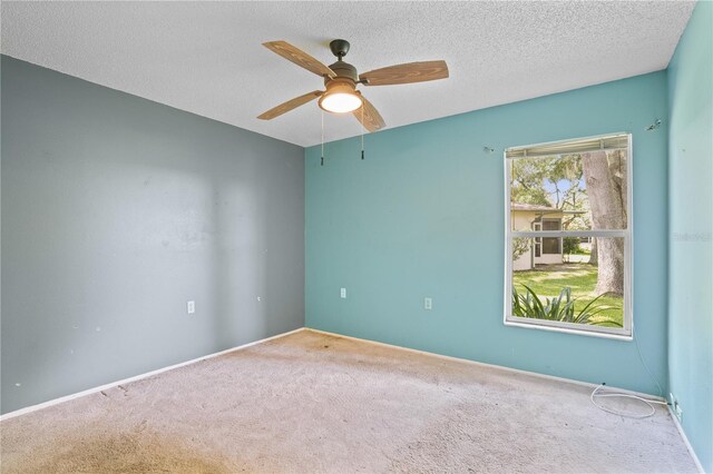 carpeted empty room featuring a textured ceiling and ceiling fan