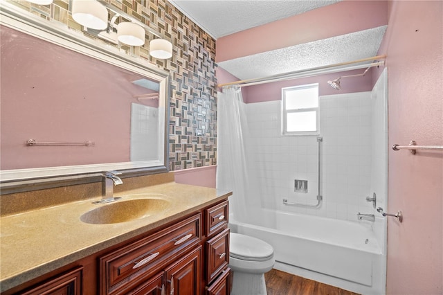 full bathroom with a textured ceiling, wood-type flooring, toilet, shower / bath combo with shower curtain, and vanity