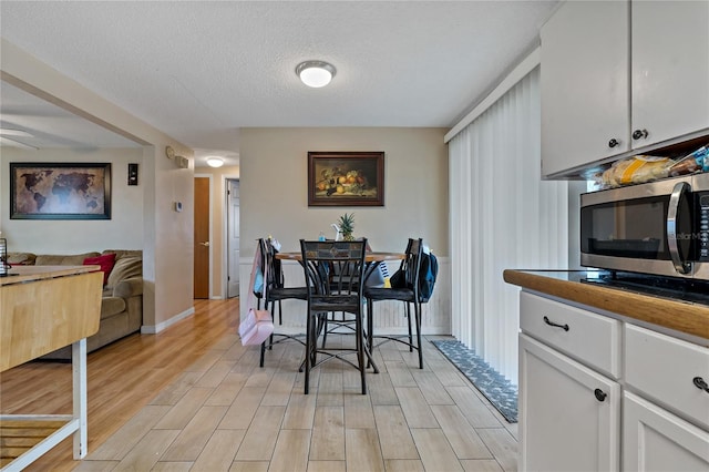 kitchen with ceiling fan, light hardwood / wood-style floors, and white cabinetry