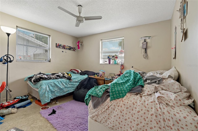 carpeted bedroom with a textured ceiling and ceiling fan