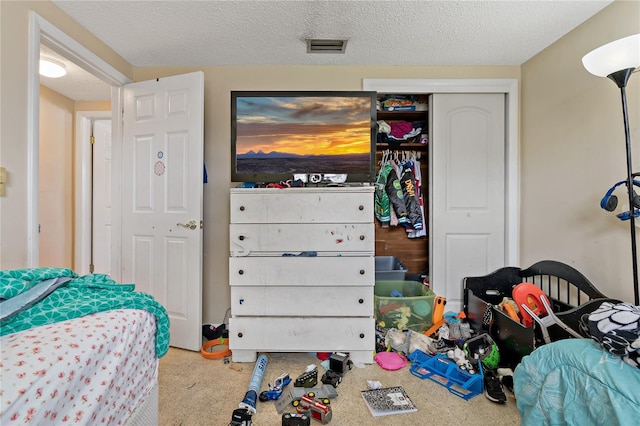 carpeted bedroom with a textured ceiling and a closet