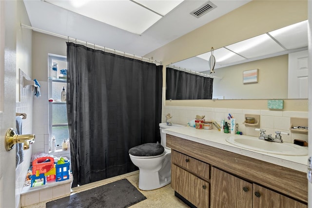 bathroom with vanity, toilet, walk in shower, and tasteful backsplash