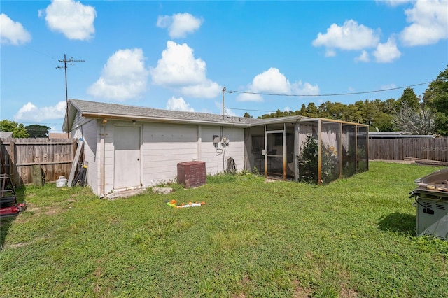 rear view of property with a lawn and a shed