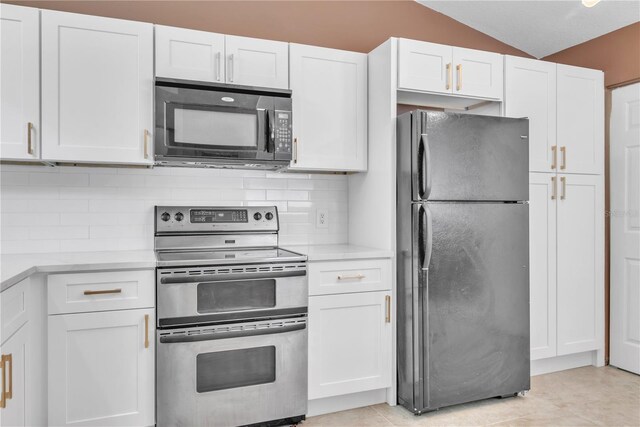 kitchen featuring black appliances, white cabinetry, backsplash, and lofted ceiling