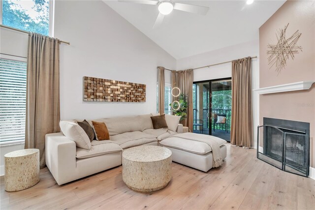 living room with high vaulted ceiling, ceiling fan, light hardwood / wood-style flooring, and plenty of natural light