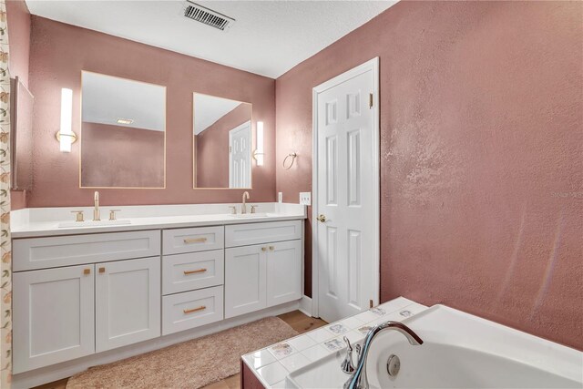 bathroom with vanity and a bath